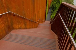 Stairs and handrail made out of rusty steel panels. Modern look of rust on the construction elements such as stairs or walkways.