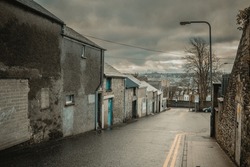 Typical street in city of Derry or Londonderry, visible lower part of the town and classical cloudy and a bit rainy weather in early spring.