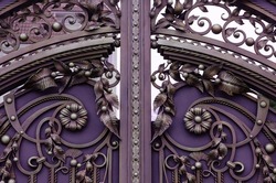 Beautiful decorative elements of wrought iron gates in purple