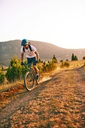 Cyclist Riding the Bike on the Trail in the Forest. Man cycling on enduro trail track. Sport fitness motivation and inspiration. Extreme Sport Concept. Selective focus. High-quality photo