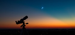 Silhouette of a astronomy telescope with twilight sky.