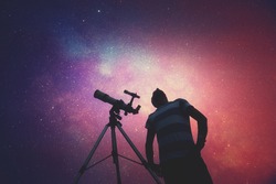 Man looking at the stars with telescope beside him. My astronomy work.