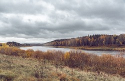 Landscape view on the bend of Daugava river, forest and meadow at Naujene parish, Daugavpils district, Latgale region, Latvia, which is a part of Nature Park â€œDaugavas Lokiâ€ on autumn overcast day
