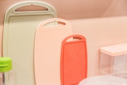 Various plastic cutting boards on the table. Kitchen utensils and accessories in trendy pastel colors