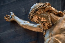 Bronze sculpture of crucified Jesus. Selective focus area.