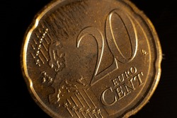 A close-up of a twenty-cent euro coin. Close-up of twenty euro cent coins on the table. Euro coin with selective focus