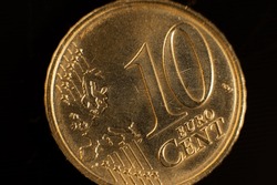 Close-up of a ten cent euro coin. Close-up of ten euro coins on the table. Euro coin with selective focus