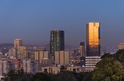 Landscape photo of the city of Pretoria in South Africa at sunrise with sun reflecting on the reserve back.