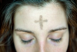 woman with cross on forehead in observance of Ash Wednesday religious concept