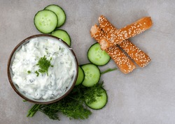 Fresh Greek favorite, Tzatziki made with cucumber, yogurt and herbs. On a mottled grey surface with copy space
