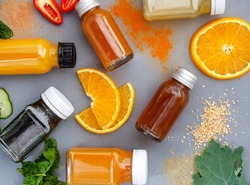 Juice shots for a healthy lifestyle, flat lay on dark grey with ingredients