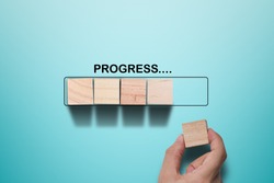 Hand putting wooden cube on virtual infographic rectangle block with progress wording. Job progressive concept.