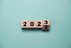 Flipping of 2022 to 2023 on wooden block cube for preparation new year change and start new business target strategy concept.