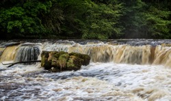 Dramatic shot of raging water cascading down river