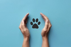 The silhouette of an animal's paw in a human hand. Animal Protection Symbol