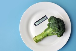 A table with the number of calories in food on a plate. The number of calories in broccoli