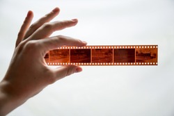 Film photography special envelope slips for negative storage. 35mm and medium format photography. A hand holding a film strip in front of white background.