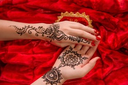 Oriental picture on woman hand palm, horizontal banner. mehendi traditional decoration, resistant design, brown henna tattoo art. Saloon service style, mandala lily flower, bright red cloth background