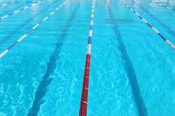 Lanes of sport swimming pool with turquoise water. Swimming pool with a lot od space for text. Swimmingpool lane markers. Swimming pool of olimpic type is ready for competition. Swimming pool surface.