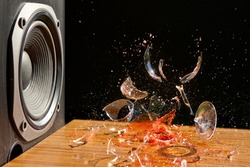 Loud Music Can Cause Damage - Studio Shot of Glass of wine exploding in front of a loud Subwoofer