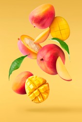 Fresh ripe mango with leaves falling in the air isolated on yellow background. Food levitation concept. High resolution image