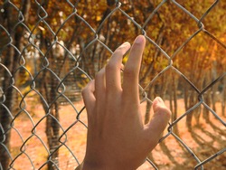 The handle on the fence represents the absence of freedom and detention.