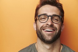 Man laughing in orange studio, close up