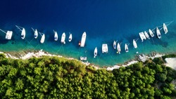 Aerial drone top down photo of sail boats and yachts anchored in traditional fishing village of Fiskardo, Kefalonia island, Ionian, Greece