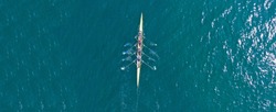 Aerial drone top down ultra wide panoramic view of sport canoe rowing synchronous athletes competing in tropical exotic lake