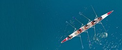 Aerial drone ultra wide top down photo of sport canoe with young team of athletes practising in deep blue open ocean sea