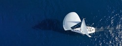 Aerial drone ultra wide panoramic photo with copy space of beautiful sail boat with white sails cruising deep blue sea near Mediterranean destination port