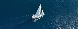 Aerial drone ultra wide photo of beautiful sailboat cruising deep blue open ocean Mediterranean sea