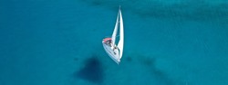 Aerial drone ultra wide photo of beautiful sail boat sailing in turquoise Ionian island sea