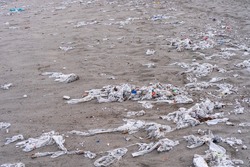 Beach full of garbage, wet wipes and waste that people throw in the toilet. Concept of ocean pollution and environmental destruction