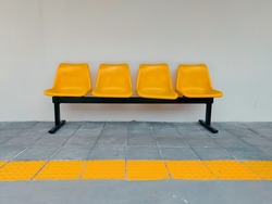 Yellow bench next to the wall.
