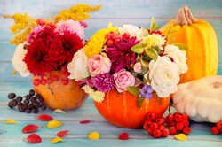 Flowers in a pumpkin. Bright autumn background. Colorful autumn card. Pumpkin with fresh flowers. Autumn flower arrangement. Autumn bouquet.