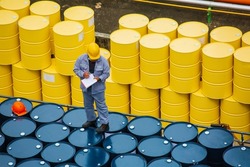 Male worker inspection record drum oil stock barrels yellow vertical or chemical for transportation truck male in the industry.