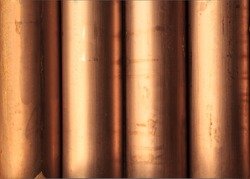 Creative abstract heavy non-ferrous metallurgical industry and industrial manufacturing business production concept: heap of background shiny metal copper pipes with selective focus effect