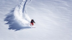 Free ride skier skiing down through fresh powder