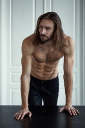 Handsome brutal man with beard and cool long hair.Sexy topless athletic body . Confident, attractive, stylish. Fashion shooting. Actor.