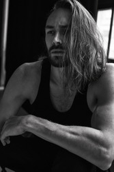 Handsome brutal man with beard cool long hair style.Sexy Businessman. Confident, attractive, stylish. Fashion shooting. Actor. Black and white