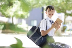 Junior high school student sitting on a park bench and reading