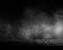 Wooden table with smoke and black backgrounds