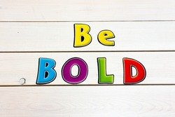Be Bold. Positive affirmation statement. Bold neon letters on white washed background.