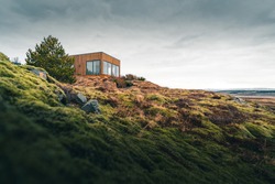 A tiny house on a grassy hill perfect for isolated vacation or just a peaceful relax in the connection with nature. Modern architecture in the Scandinavian countries
