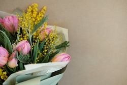 a variety of flowers in a bouquet on a beige background