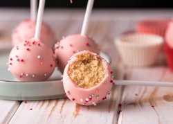 The pastry chef decorates cake pops with satin ribbons. Desserts with pink cream. Tasty food