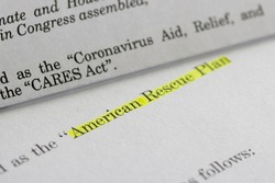 Closeup of the documents of both the Cares Act (Coronavirus Aid, Relief, and Economic Security Act) and the American Rescue Plan Act (ARPA) of 2021.
