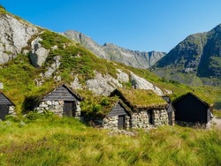 Bjorndalssetra, beautiful, historic stone buildings in the mountains of Folgefonna National Park in Norway. Old houses with grass roofs near the lake.