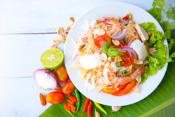 Spicy Vermicelli Seafood Salad with vegetable ingredient on wood white background, Thai food Street food Concept.Top View